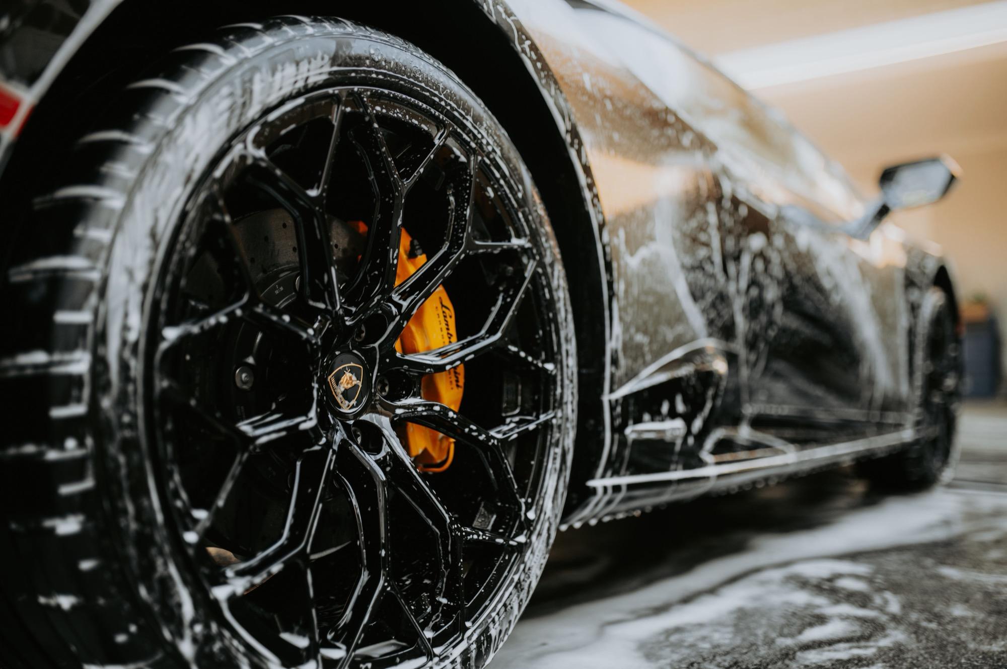 Foam covering a wheel and lower body panel during the wash stage